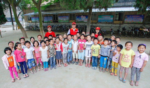 图为5月29日，国网滑县供电公司的青年志愿者在桑村乡齐邱村小学和1年级1班的孩子们合影留念。