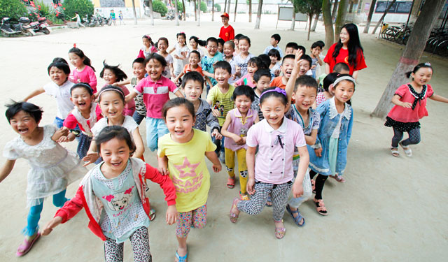 图为5月29日，国网滑县供电公司的青年志愿者在桑村乡齐邱村小学和1年级1班的孩子们合影留念。