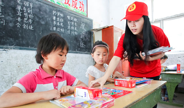 图为5月29日，国网滑县供电公司的青年志愿者在桑村乡齐邱村小学1年级1班正在给孩子们发放图书文具和安全用电宣传画。