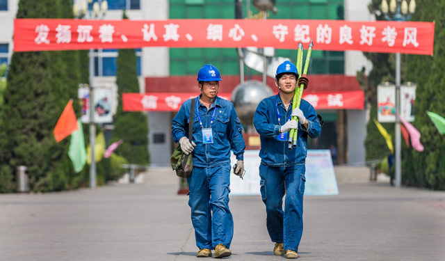 2015年6月7日，高考第一天，河南滑县县城及城关镇的4个考点内，分别出现了头戴安全帽、身穿工作服的40名高考保电突击队员。图1为6月7日，国网河滑县供电公司2名高考保电服务队员在滑县一中考点内巡视线路。