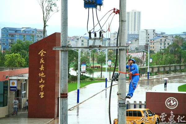 1、下着雨的校门外，供电职工正在对转供电源开光进行状态评估，以应对即将来临的高考。（王仁磊 摄）.JPG