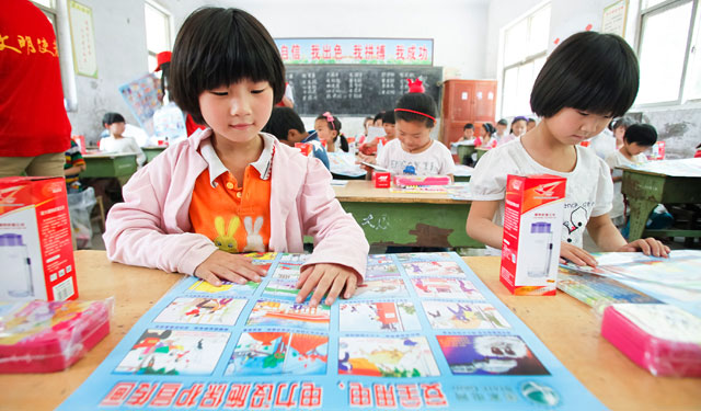 图为5月29日，国网滑县供电公司的青年志愿者在桑村乡齐邱村小学1年级1班正在给孩子们讲解安全用电宣传画的内容。