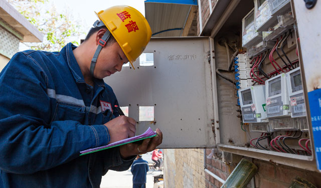 图为4月20日，河南滑县道口镇教育路，电力施工人员正在记录用户电表信息为更换做准备。