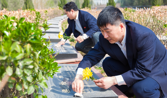 图为4月1日，河南滑县烈士陵园内该县电力员工正在为梁栓柱烈士擦净墓碑敬献鲜花。