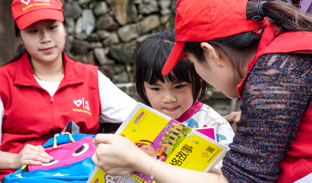 5月30日，余庆县构皮滩镇红旗村，在10岁的李龙飞家里，志愿者们一边赠送学习用具，一边通过交谈了解他的生活境况。