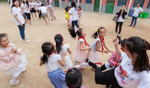 图为6月3日，国网滑县供电公司组织青年志愿者，在该县瓦岗赤水小学“十分有爱”童书馆前和孩子们一起做游戏。