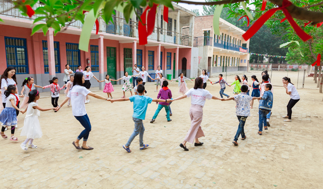 图为6月3日，国网滑县供电公司组织青年志愿者，在该县瓦岗赤水小学“十分有爱”童书馆前和孩子们一起做游戏。