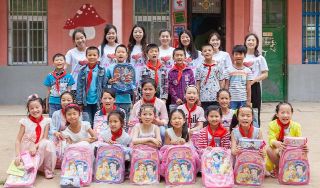 图为6月3日，国网滑县供电公司组织青年志愿者，在该县瓦岗赤水小学“十分有爱”童书馆前和孩子们一起合影留念。