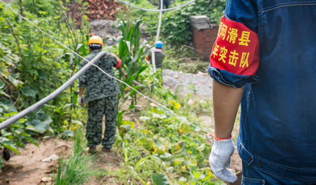 据滑县供电公司抢险负责人姚晓宁介绍，截至25日20时30分， 该公司主要负责4个行政村的恢复供电任务，下庄村、西蒋村、小寨村和河西村共有人口7000余人。现在已经恢复了2个台区的供电，预计明天(7月26日)将全部恢复供电。图为7月25日，国网河南滑县供电公司共产党员、青年突击队员在37度的高温下顶着烈日，正在河南安阳县许家沟乡下庄村架设临时电缆，以保障受灾群众尽快用上电。