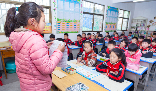 志愿者还精心为同学们准备了笔记本、圆珠笔等学习用品。图为2017年3月15日，滑县半坡店乡滑南希望小学六年级一班的教室内，该校六年级学生马思晨在讲台上满怀深情地读起了自己写给父亲的信。