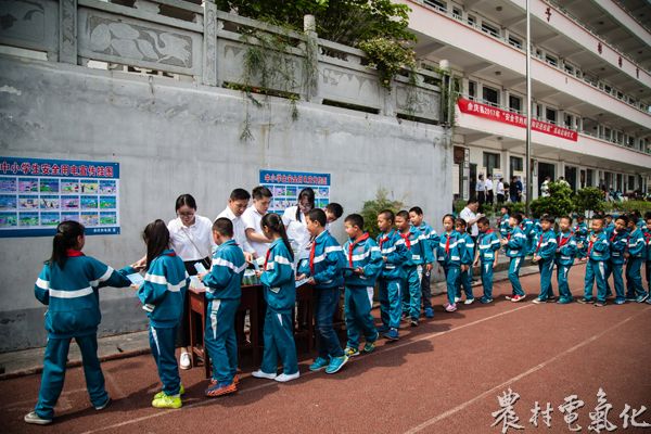 2、5月10日，实验小学的学生们，正在排队领取用电宣传画册及印有安全用电漫画的作业本。（王仁磊 摄）.jpg