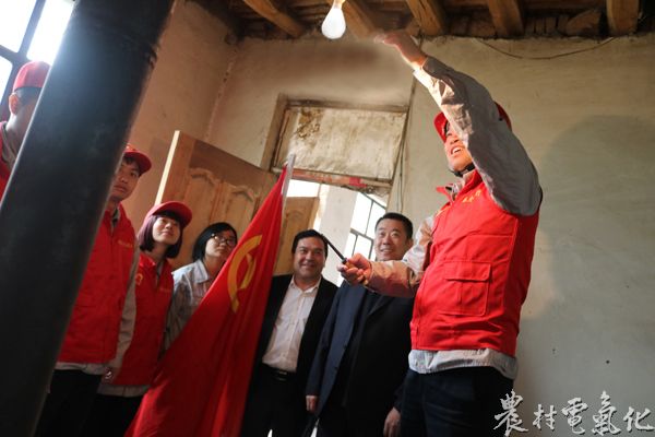 青年志愿者在为托合提买买提老人安装灯泡.JPG