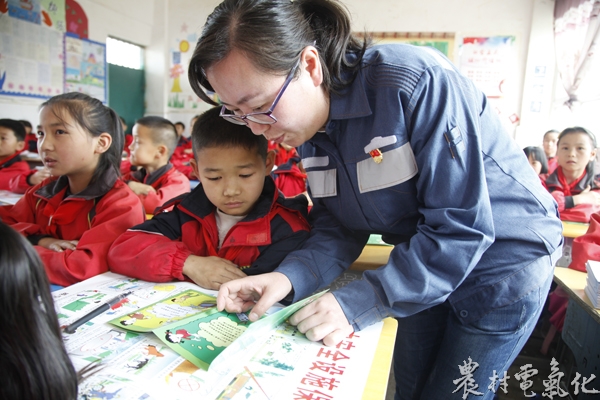 （尚昆摄）图为威宁供电局党员朱青青正在向威宁县五里岗小学三年级学生介绍安全用电知识.JPG