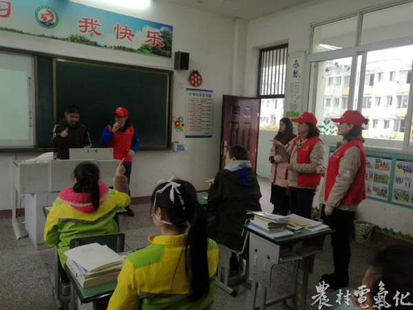 国网遂宁供电公司张开国志愿者服务队队员彭举向特校学生学习手语.JPG