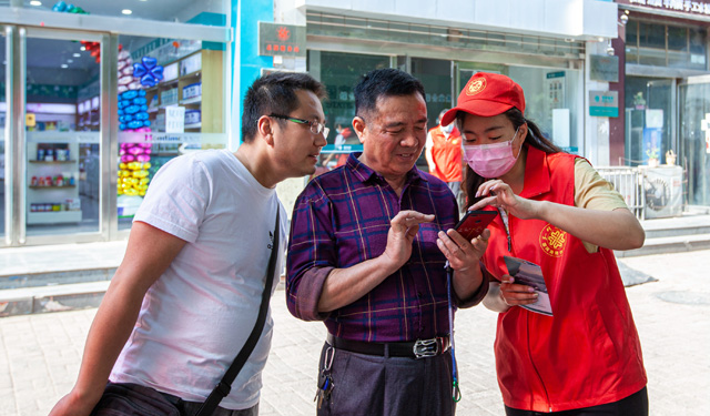 “网上国网”功能更强大，办理用电更加方便快捷，通过查看APP，客户能实时看到用电量，了解家中用电数据，真正让民众用上明白电、放心电。图为，2020年5月20日，河南滑县英民路新区供电营业厅前，国网滑县供电公司志愿者杨宁（右1）帮助市民下载安装“网上国网”APP。