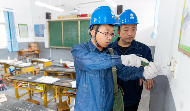 2020年6月1日，麦穗金黄，风吹麦香，第71个国际儿童节如约而至。河南滑县瓦岗寨乡马庄村马庄小学迎来电力“小红帽”志愿者，他们带着精心准备的小礼品来到校园，开展“六一童乐 特别关爱”主题活动，和小朋友们一起欢度六一。图为，2020年6月1日，河南滑县瓦岗寨乡马庄村马庄小学，电力“小红帽”志愿者为学校检查用电设备。