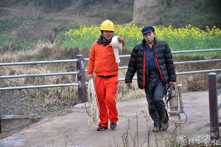 周兴明在村里指导村民安装抽水设备.JPG