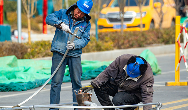 图为2月27日，在河南滑县新濮路中段的220千伏高压线路上，电力施工人员正在60米高的铁塔上紧固导线，确保本次迁改工程的有序完成，为地方经济社会高质量发展提供了坚实保障。